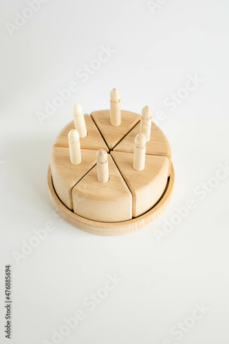 wooden toy cake from natural material, eco on minimalistic background photo