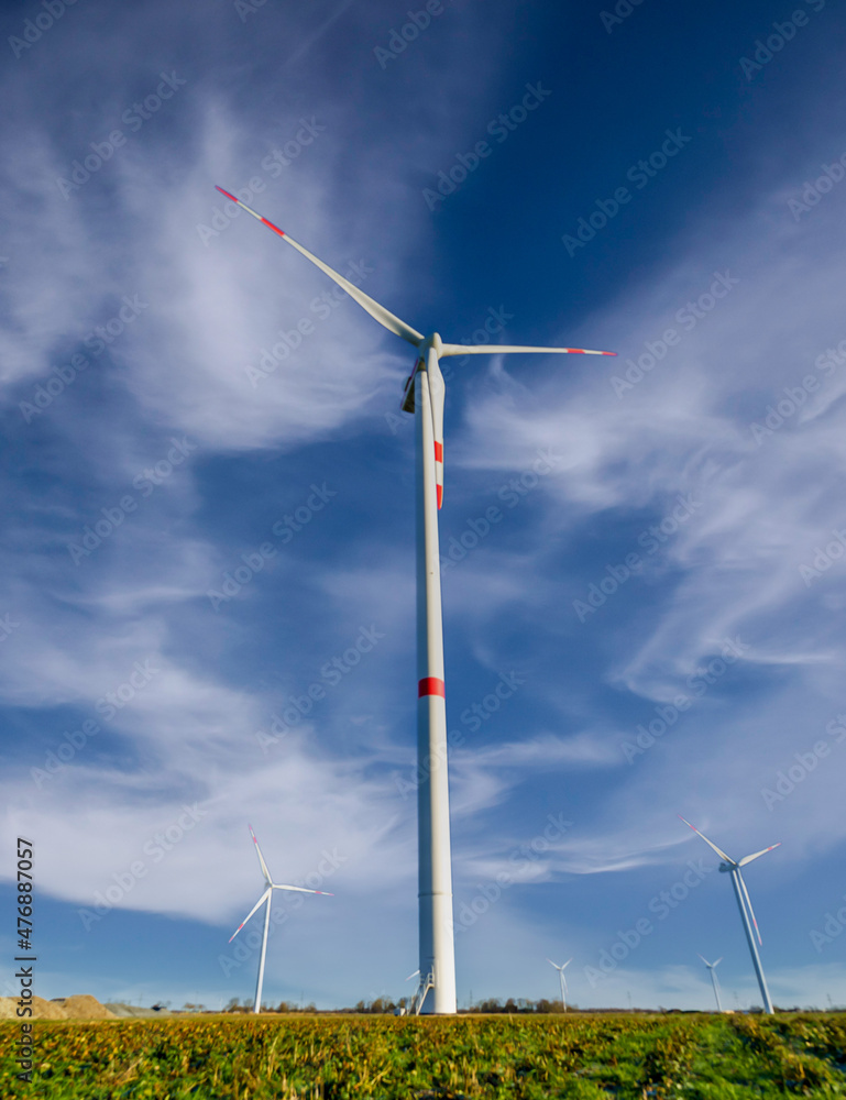 Green meadow with wind turbines for power generation Green meadow with wind turbines for power generation
