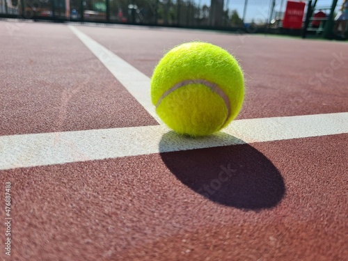 Tennis ball on the sunny hard court аnd the service line. © ILLyas IDOL