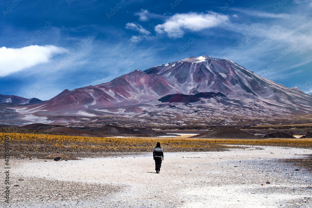 Hombre caminando en cercania de los volcanes del recorrido de los seismiles. Provincia de Catamarca, Argentina