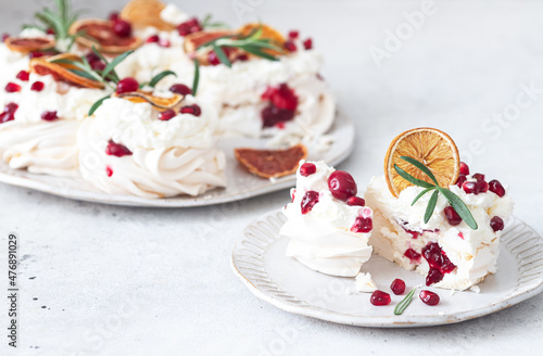 Meringues pavlova cake wreath with whipped cream, pomegranate and orange	