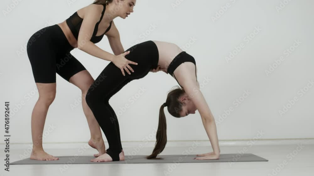 Sporty women stretching in a fitness studio. Healthy lifestyle. Yoga. Pilates. Young athletic women are practicing indoors. stretching exercises with a coach Sporty women stretching in a fitness studio. Healthy lifestyle. Yoga. Pilates. Young athletic women are practicing indoors. stretching exercises with a coach