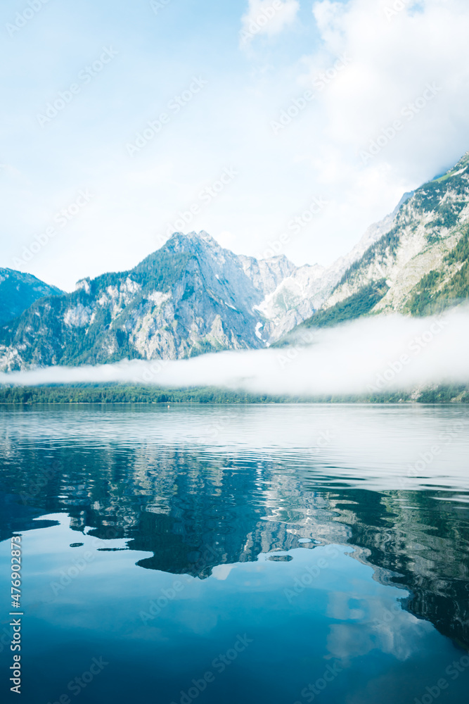 Naklejka premium Reflecting Mountains and Fog in the Water of the Koenigssee (Königssee) in the Berchtesgadener Land, Bavaria, Germany