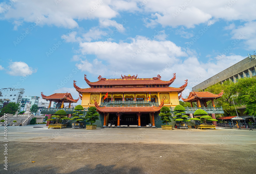 Quoc Tu Pagoda in Vietnam, Ho Chi Minh.Red tall asian temple on the blue sky background in Saigon. It is a famous pagoda in Ho Chi Minh city. Travel and religion concept.