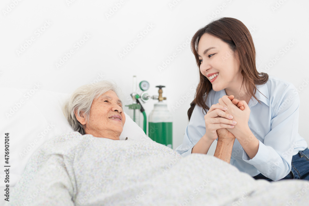 old asian patient sick and admit in hospital, young asian female visiting old female, they holding hands together,  they feeling happy and smile, elderly healthcare