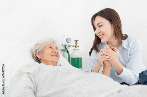 old asian patient sick and admit in hospital, young asian female visiting old female, they holding hands together,  they feeling happy and smile, elderly healthcare © jokekung