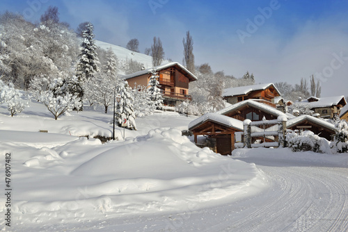  chalets in alpine village covered with snow at the end of a white rural road