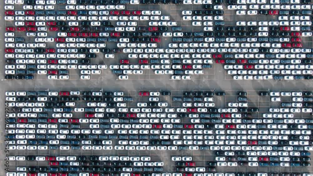 Long rows of finished white black red and blue automobiles on open warehouse parking lot of car factory giant aerial view Long rows of finished white black red and blue automobiles on open warehouse parking lot of car factory giant aerial view