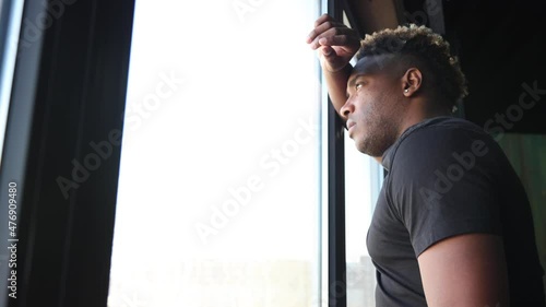 Thoughtful African businessman, standing in a skyscraper at the window and looking at the city, immersed in his thoughts, thinks about the goal, the future project, the desire for a career.