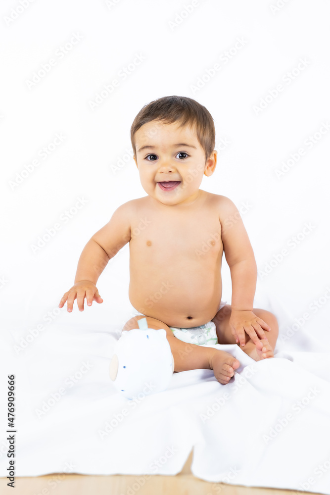 Baby boy in a studio with a white background, newborn caucasian eight months old smiling, vertical photo Baby boy in a studio with a white background, newborn caucasian eight months old smiling, vertical photo