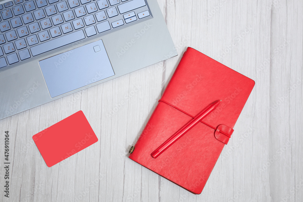 Blogger or freelancer workspace with red notebook, card, pen and keyboard on white background. Concept business antd communication Blogger or freelancer workspace with red notebook, card, pen and keyboard on white background. Concept business antd communication