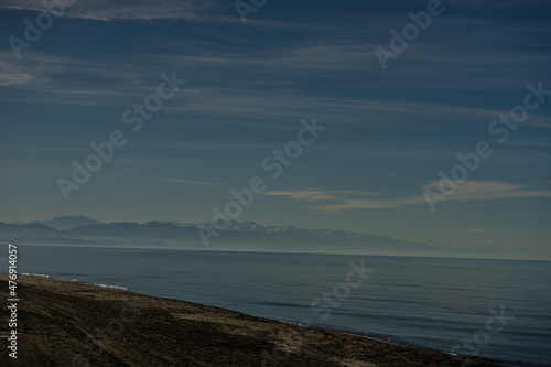 Black volcanic sand beach and Caucasus mountains photo