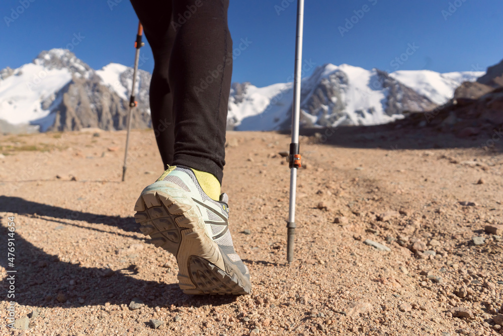 Traveler with trekking poles is walking in the mountains. Traveler with trekking poles is walking in the mountains.
