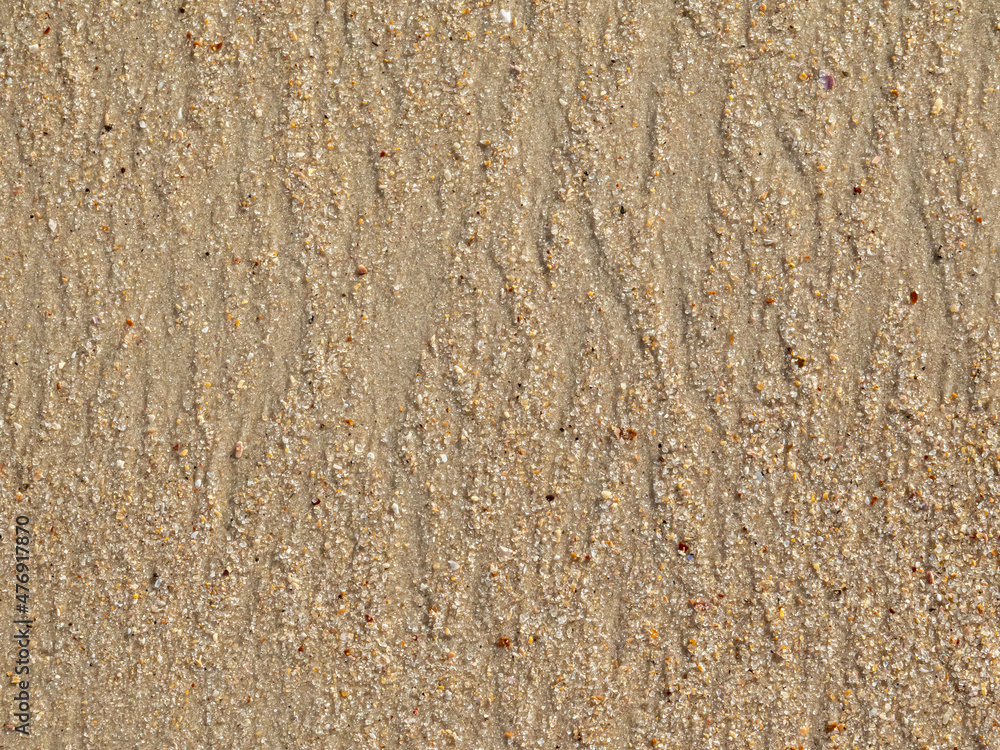 Fototapeta premium Lines in the sand of natural waves forming lozenge patterns when ocean waves return to the ocean. Conceptual image about the patterns we create in life.