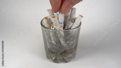 Close-up shooting. A man puts out a cigarette. Slow motion. Dirty ashtray.