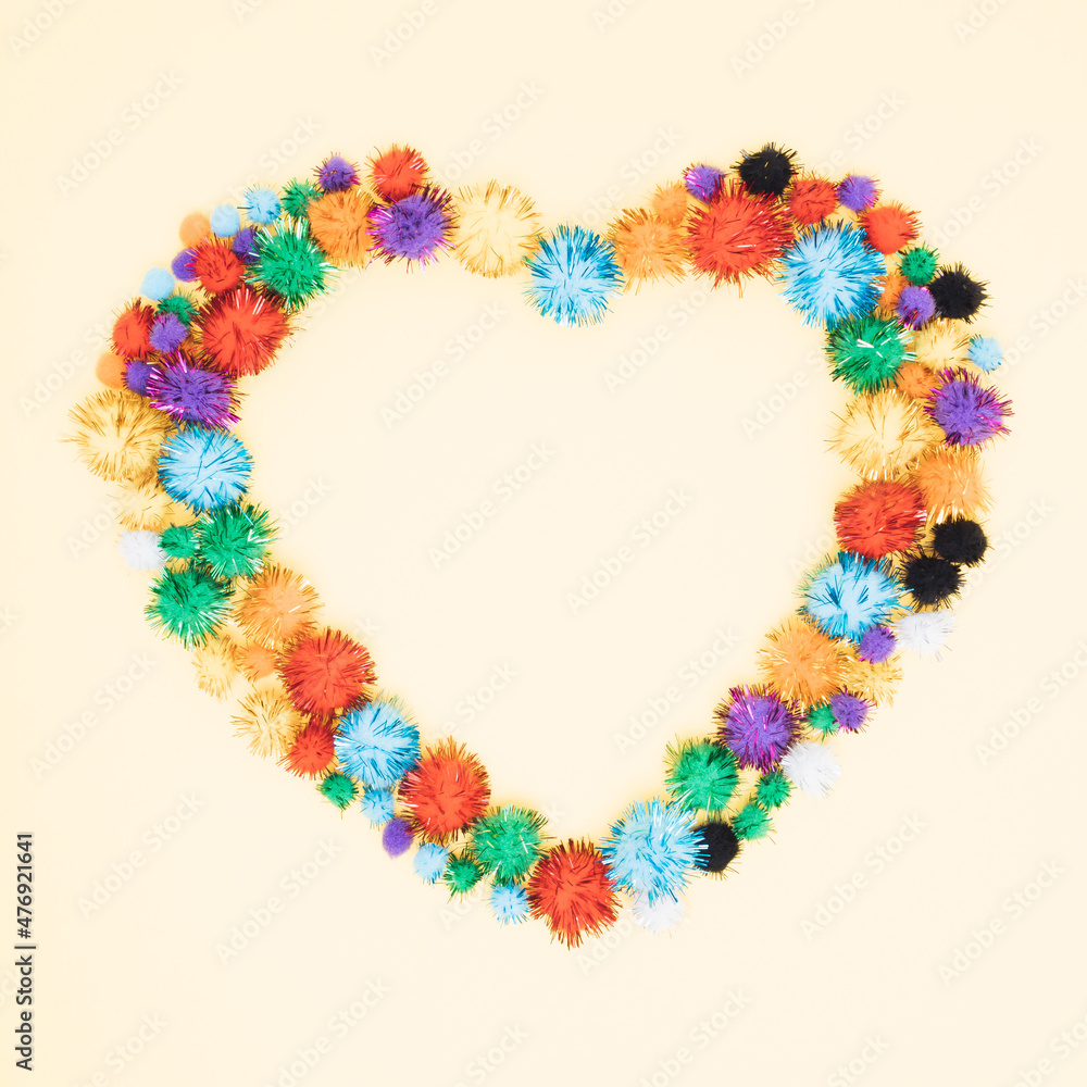 Heart symbol made of pompoms  on pastel  background.