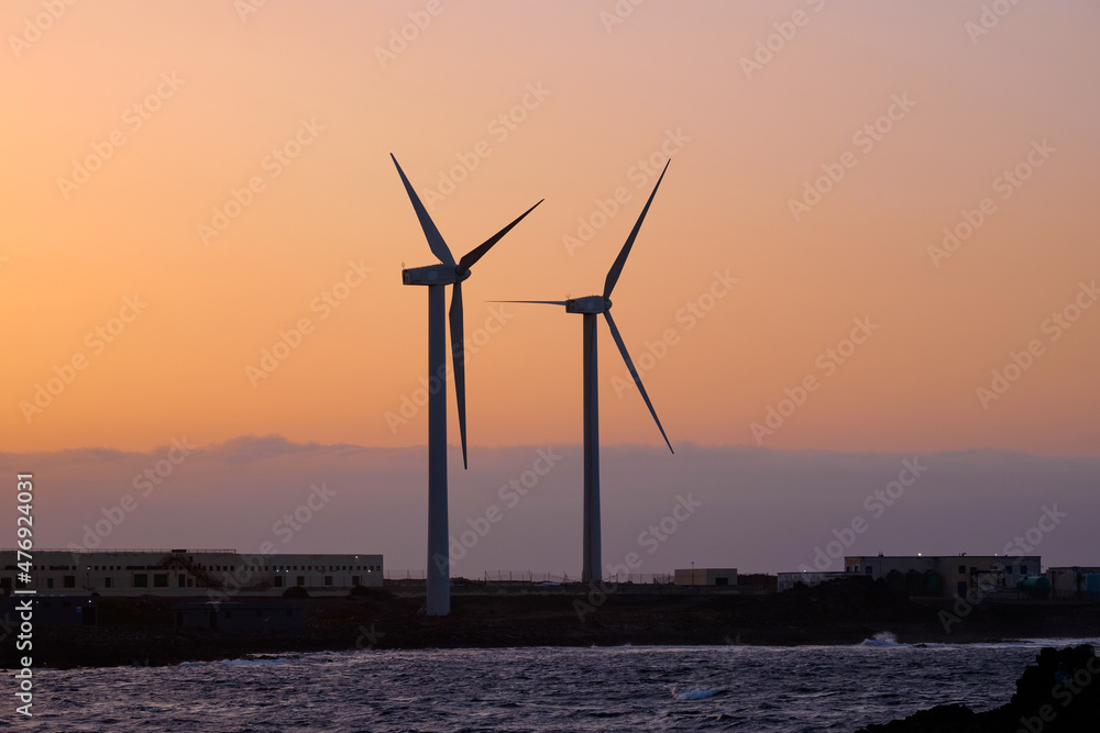 View of two wind farms at sunset.