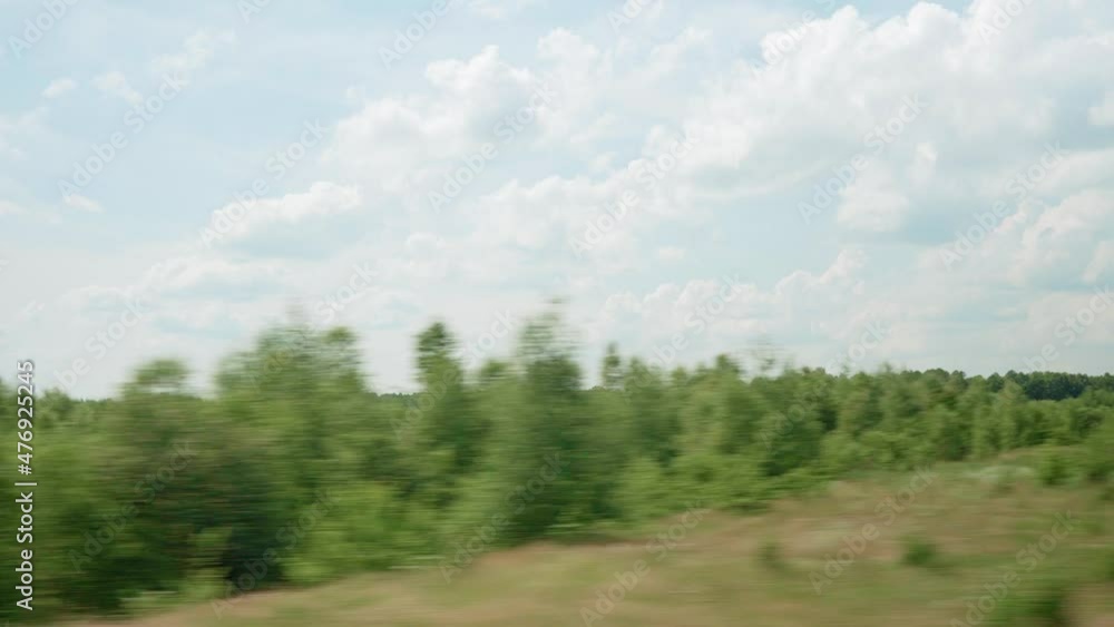 view from window of high-speed train on landscape of beautiful nature wild field and forest on evening cloudy dusk sky sunset in summer background. Transport, travel, railway, communication concept view from window of high-speed train on landscape of beautiful nature wild field and forest on evening cloudy dusk sky sunset in summer background. Transport, travel, railway, communication concept