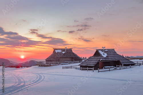 Traditional cottages on Velika Planina at sunrize in winter, Slovenia photo