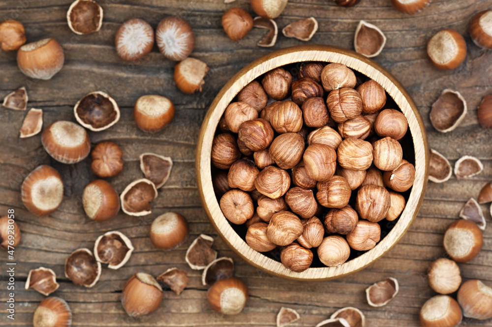Bowl of hazelnuts on rustic wooden background; nuts for healthy diet snack; vegan food background, selective focus Bowl of hazelnuts on rustic wooden background; nuts for healthy diet snack; vegan food background, selective focus