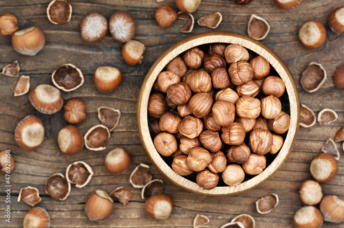 Bowl of hazelnuts on rustic wooden background; nuts for healthy diet snack; vegan food background, selective focus