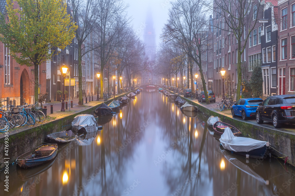 Evening Amsterdam canal Groenburgwal with Zuiderkerk, southern church, in the morning mist, Holland, Netherlands.