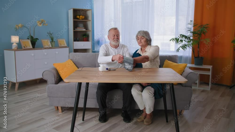 hypertension and hypotension, elderly couple use electric tonometer for measuring blood pressure at home hypertension and hypotension, elderly couple use electric tonometer for measuring blood pressure at home