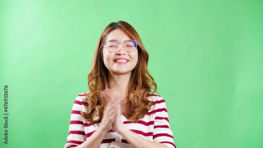 Asian women with eyeglasses in the studio clapping being positive emotions on chroma key green screen. Asian women with eyeglasses in the studio clapping being positive emotions on chroma key green screen.