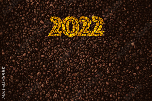 Inscription 2022 on a coffee beans background   roasted  barista  new year  top view