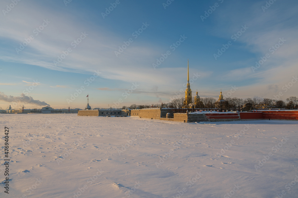 View of the Peter and Paul Fortress and Vasilievsky Island from the Trinity Bridge over the Neva River on a sunny winter morning with clouds, St. Petersburg, Russia