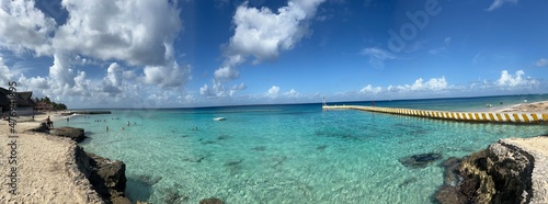 Fototapeta Naklejka Na Ścianę i Meble -  People swim and snorkel in perfect crystal clear blue water in Mexico. Tourists enjoying beautiful carribean sea in Cozumel.