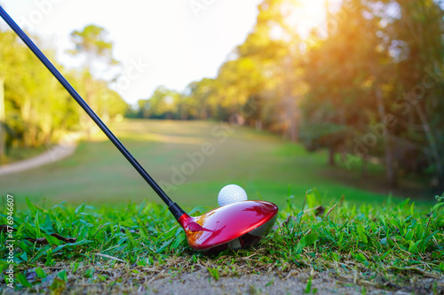 Golf clubs and golf balls on a green lawn in a beautiful golf course with morning sunshine. golf ball on green grass ready to hit on golf course background