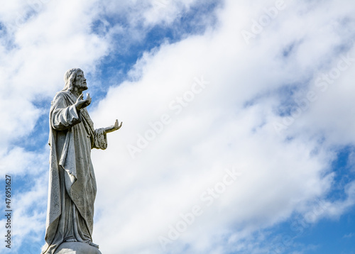 Jesus Christ statue standing against the cloudy sky day.