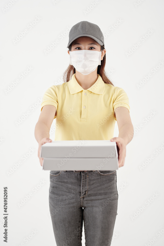 Portrait of courier in protective mask holding boxes of pizza Portrait of courier in protective mask holding boxes of pizza