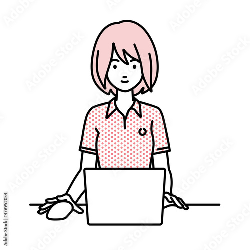 デスクで座ってPCを使っているポロシャツの女性