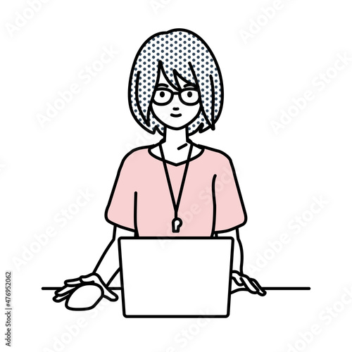 デスクで座ってPCを使っている教師の女性