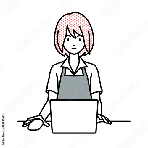 デスクで座ってPCを使っているカフェ店員の女性