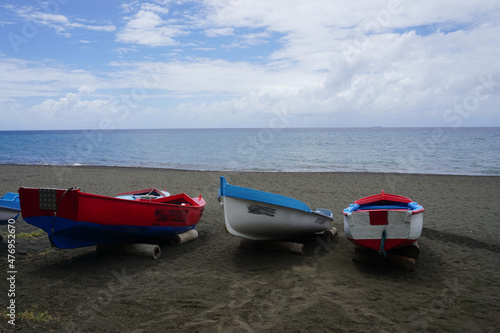 colorful boats on the black sand beach on the tropical island of la réunion france
