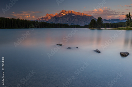 Rundle Mountain reflecting in Two Jack Lake in Banff National Park at sunrise.