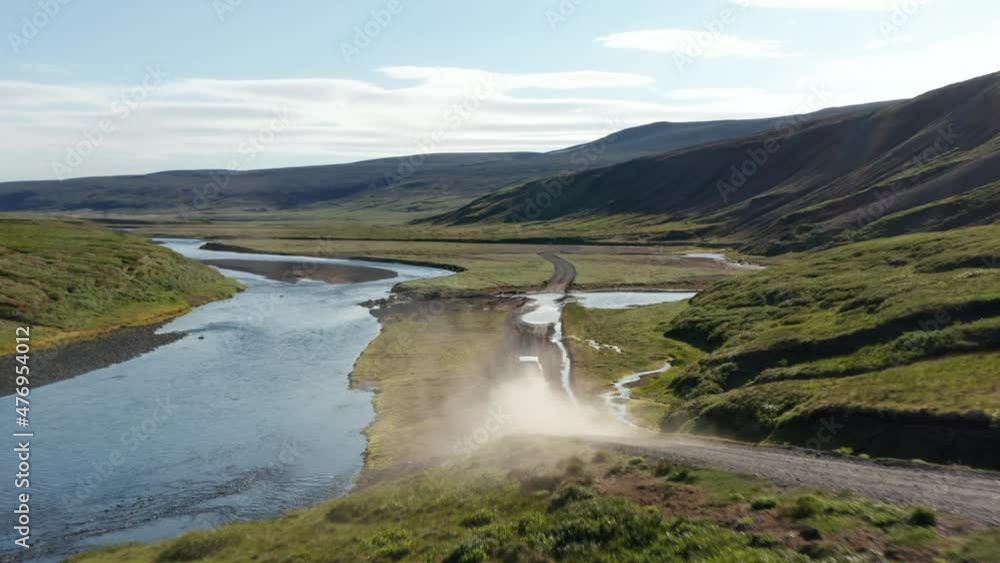 Drone view vehicle speeding on dust road in Iceland exploring amazing landscape. Aerial view off road 4x4 car driving along gravel trail path in mossy icelandic highlands. Commercial insurance Drone view vehicle speeding on dust road in Iceland exploring amazing landscape. Aerial view off road 4x4 car driving along gravel trail path in mossy icelandic highlands. Commercial insurance
