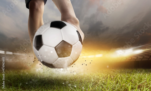 Soccer ball with football player kick off under the spot ray light effects on green field in 3D illustrations, of free space for texts and branding.