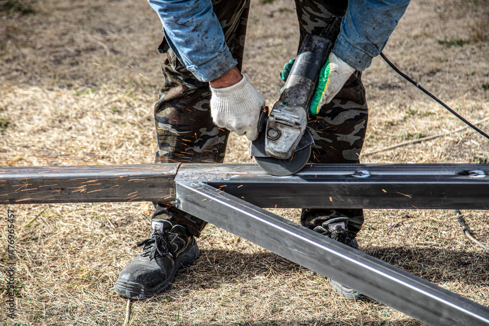 A worker cuts metal at a construction site. Technology A worker cuts metal at a construction site. Technology