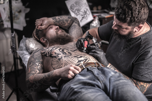 Tattoo master makes tattoo in tattoo studio