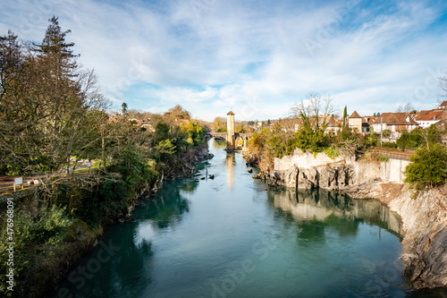 Cidade de Orthez com o rio L´adour e uma ponte com uma torre ao centro photo