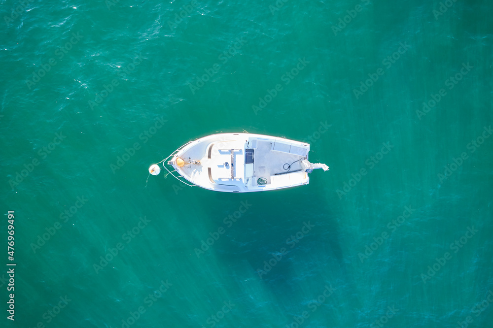 Empty fishing boat from high in atlantic. Aerial view of small white ship on green sea water. Isolated object. France. Empty fishing boat from high in atlantic. Aerial view of small white ship on green sea water. Isolated object. France.