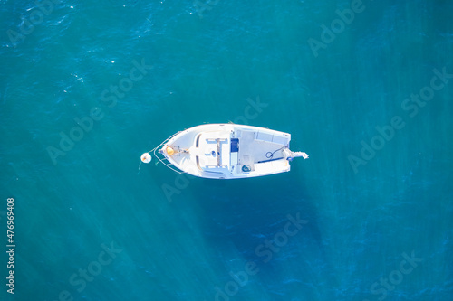 Empty fishing boat from high in atlantic. Aerial view of small white ship on blue sea water. Isolated object. France.