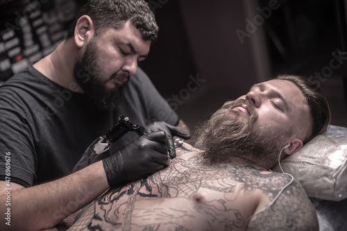 Tattoo specialist working on professional tattoo machine device in tattoo studio