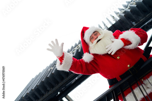 Santa claus looks down from the stairs and wishes a merry christmas outdoors