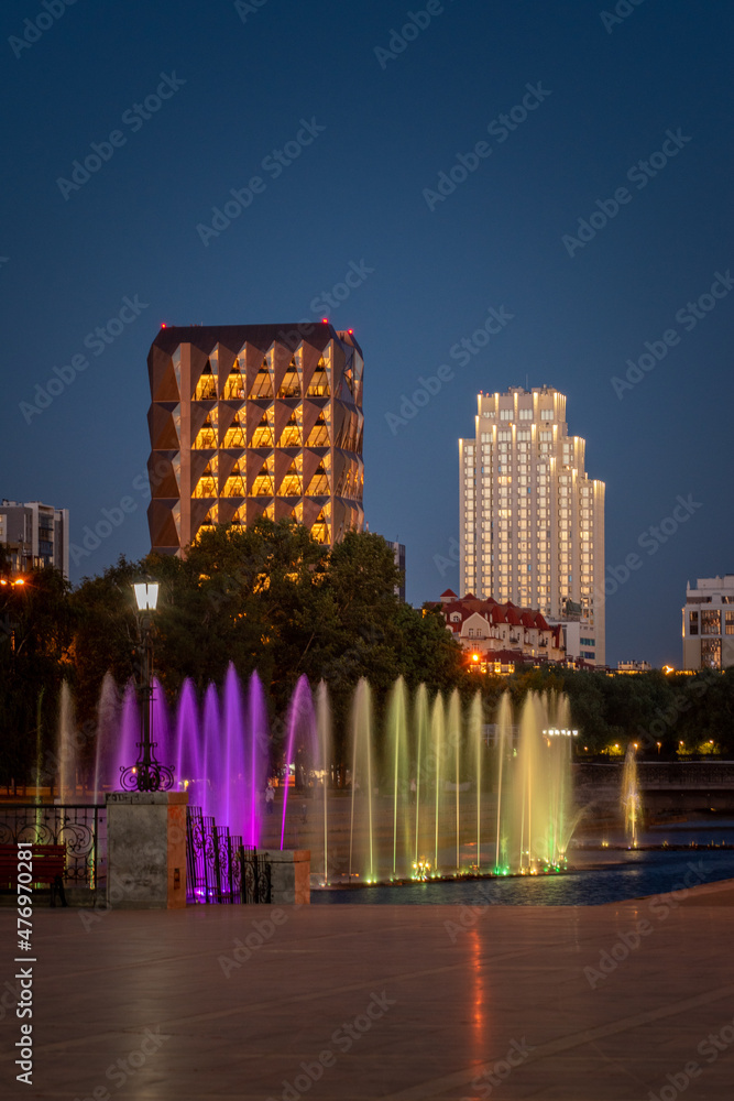 Сolored illuminated fountains and modern buildings in the center of Yekaterinburg city at summer night
