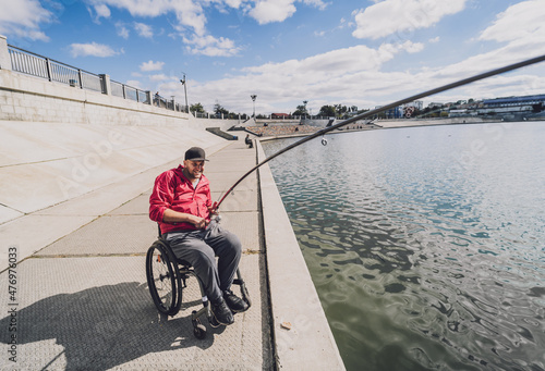 Person with a physical disability who uses wheelchair fishing from fishing pier.